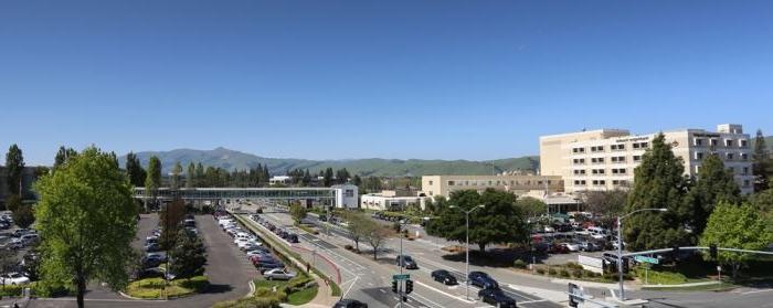 Outside of the hospital buildings showing the hospital, street, and parking lot